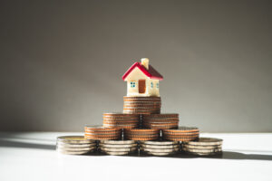 Miniature colorful house on stack coins using as propert
